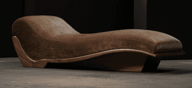 A modern chaise lounge featuring a distinctive ergonomic S-curve design. It consists of a plush, upholstered top in a brown, velvety fabric, supported by a sculptural wooden frame and base. The wood exhibits a dark, rich tone with a polished finish, highlighting its natural grain and elegant, flowing lines. The design emphasizes comfort and aesthetic form, suggesting a luxurious and contemporary piece. — 3D model