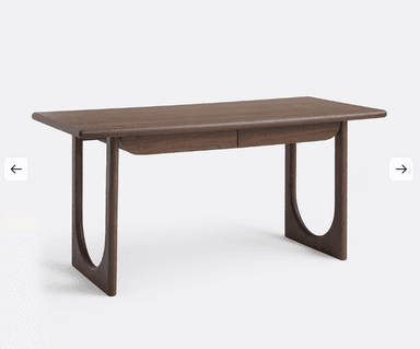 A wooden desk with a simple, modern design. It features a rectangular tabletop with slightly rounded edges and two drawers integrated into the front. The desk is supported by two curved legs on each side, creating an open base structure. The wood grain is visible, suggesting a natural wood finish. — 3D model