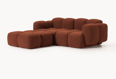 A modular sofa with a rounded, organic silhouette. The sofa is composed of several individual cubic modules that are upholstered in a textured, bouclé fabric. The arrangement suggests a sectional configuration, possibly an L-shape, with distinct seat and backrest sections, and padded armrests. The overall design is characterized by its plush, pillow-like appearance and low profile. — 3D model