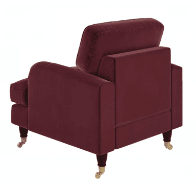 A deep red, velvet upholstered armchair featuring rolled arms with subtle pleating, a plush seat cushion, and dark turned wooden legs with brass casters. — 3D model