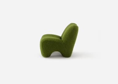 A low-slung, green, organic shaped lounge chair, entirely upholstered in a textured boucle fabric with a sculptural form, devoid of visible legs or distinct base. — 3D model