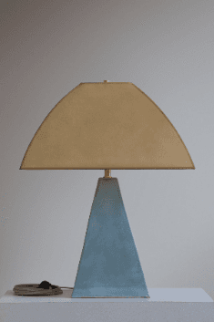 A modern table lamp featuring a pyramidal concrete base and a distinctive arched fabric shade. The design is geometric and minimalist, combining industrial and soft textures. — 3D model