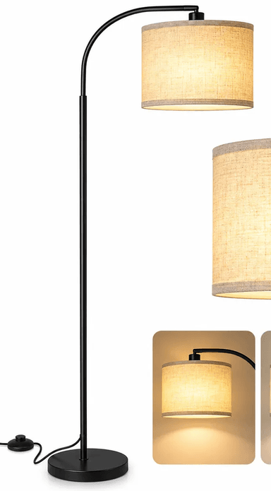 A modern arched floor lamp featuring a black metal frame, a curved neck, and a cylindrical linen-look fabric drum shade. The base is round and flat, providing stability. — 3D model