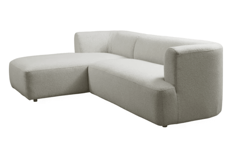 A modern sectional sofa with a chaise lounge. The sofa features a low profile, rounded arms, and a plush, textured upholstery. It is comprised of two main sections: a chaise on the left and a sofa segment on the right with an extended armrest. — 3D model