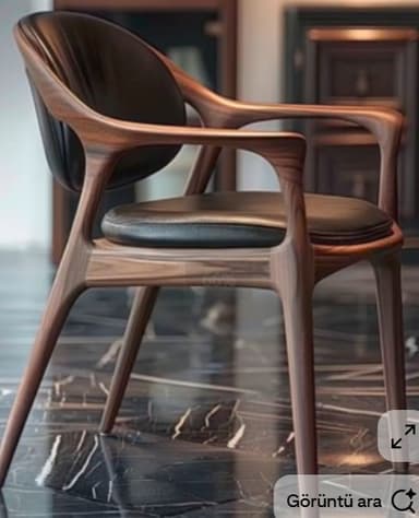 A contemporary armchair crafted from dark walnut wood, featuring a curved frame with integrated armrests and upholstered in black leather for both the seat and backrest. — 3D model