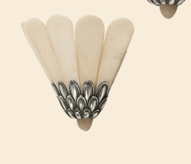 An Art Deco-style wall sconce featuring a fan-shaped shade composed of multiple translucent, off-white panels, likely alabaster. The shade is supported by an ornate cast metal base with a scalloped, leaf-like design and an antiqued silver or pewter finish. The fixture is designed for wall mounting. — 3D model