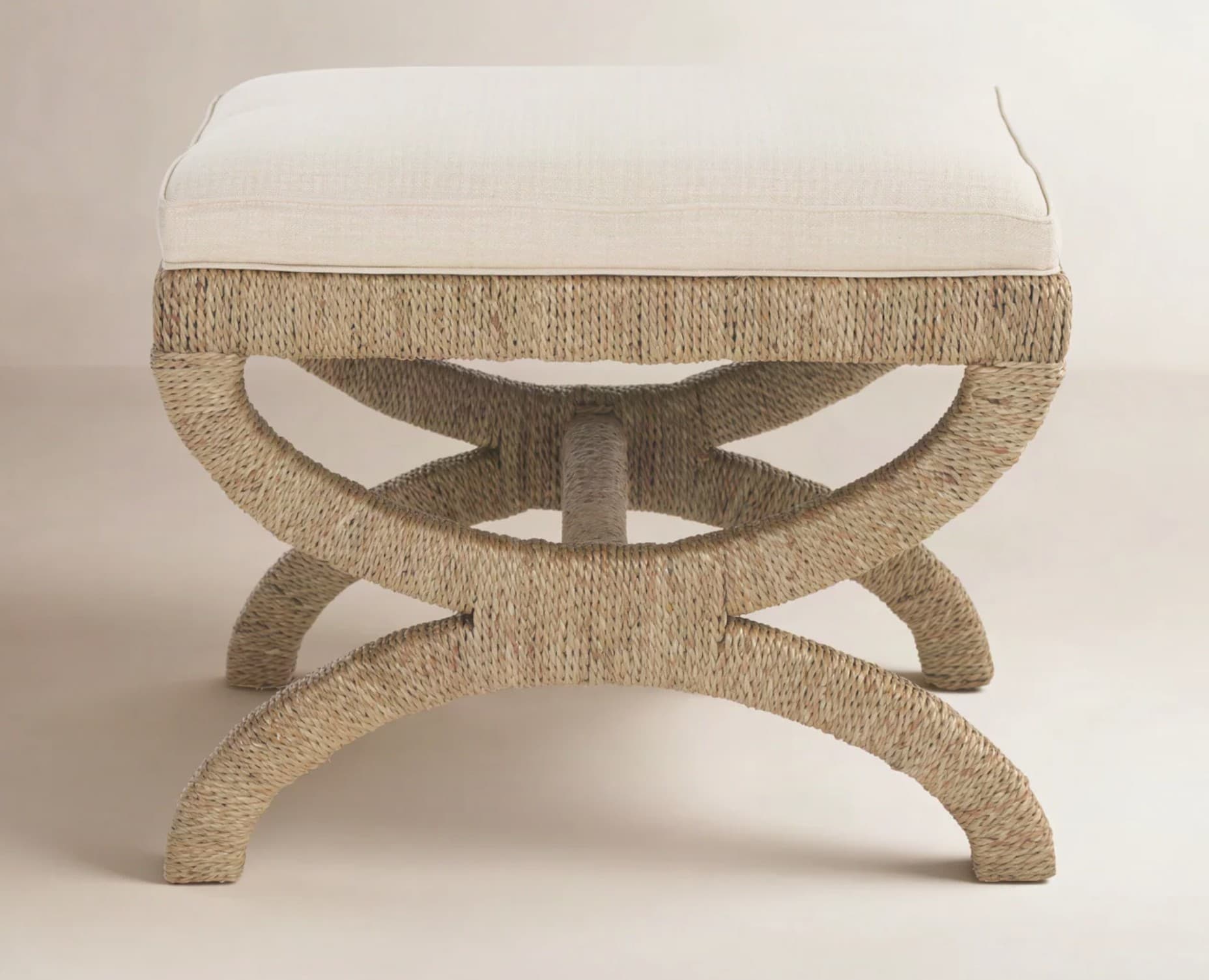 A rectangular upholstered bench featuring an X-shaped curule base fully wrapped in natural fiber rope, topped with a light cream fabric cushion. — 3D model