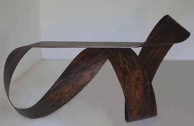 A sculptural console table with a continuous, ribbon-like form, crafted from a dark, heavily-grained wood veneer. — 3D model