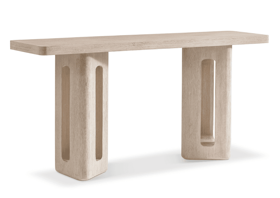 A modern, sculptural console table featuring a rectangular tabletop supported by two thick, solid pedestal legs. Each leg is designed with two elongated vertical cutouts, adding a distinctive architectural detail. The table is crafted from wood with a light, washed finish that highlights the natural grain, and all edges, including the tabletop and leg bases, are smoothly rounded. — 3D model