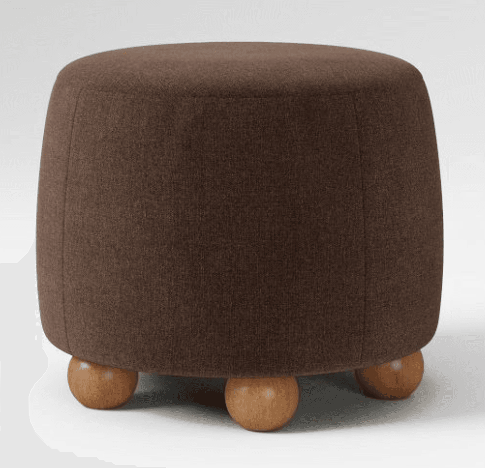 A round, upholstered ottoman with a curved body and three spherical wooden legs. — 3D model