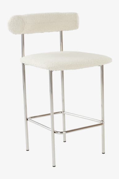 A bar stool with a curved backrest and a padded seat. The frame and legs are constructed from polished metal tubing, featuring a horizontal footrest connecting the front and back legs. The upholstery appears to be a textured, boucle-like fabric in a light cream or off-white color. — 3D model