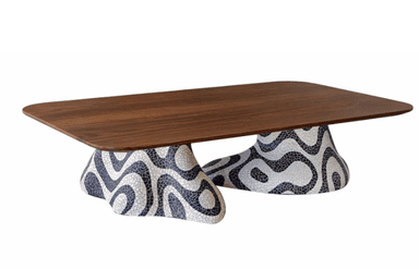 A low-profile coffee table with a distinct base. The tabletop is a rectangular slab with gently rounded corners, constructed from a warm-toned wood. The base is sculptural and appears to be made of a mosaic material, featuring an abstract, wavy pattern in black and white. The overall form suggests a modern or eclectic design aesthetic. — 3D model