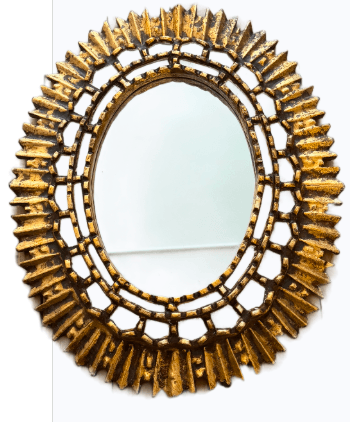 An oval wall mirror featuring a highly ornate, multi-layered sunburst frame with an antiqued gilded finish. The frame consists of an inner openwork border surrounding the oval mirror plate, from which numerous pointed, segmented 'rays' extend outwards, creating a dramatic, textured sunburst effect. The gold finish has a distressed appearance with dark patination, highlighting the intricate details and giving it an aged, historical character. — 3D model