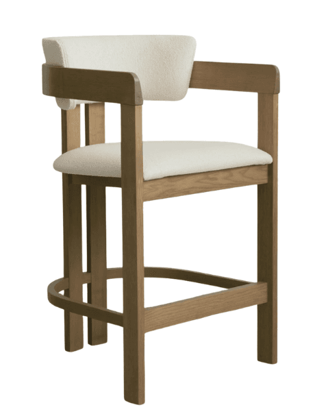 A contemporary bar stool featuring a sturdy light-toned wooden frame, an upholstered backrest and seat in textured cream fabric, and integrated armrests. It includes a circular footrest for comfort and stability. — 3D model