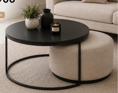 A modern nesting furniture set consisting of a round coffee table with a black metal frame and a circular black tabletop, and a complementary round upholstered ottoman in a beige fabric that fits beneath the table. — 3D model