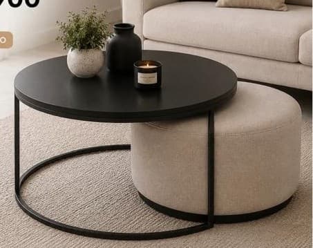 A modern nesting furniture set consisting of a round coffee table with a black metal frame and a circular black tabletop, and a complementary round upholstered ottoman in a beige fabric that fits beneath the table. — 3D model