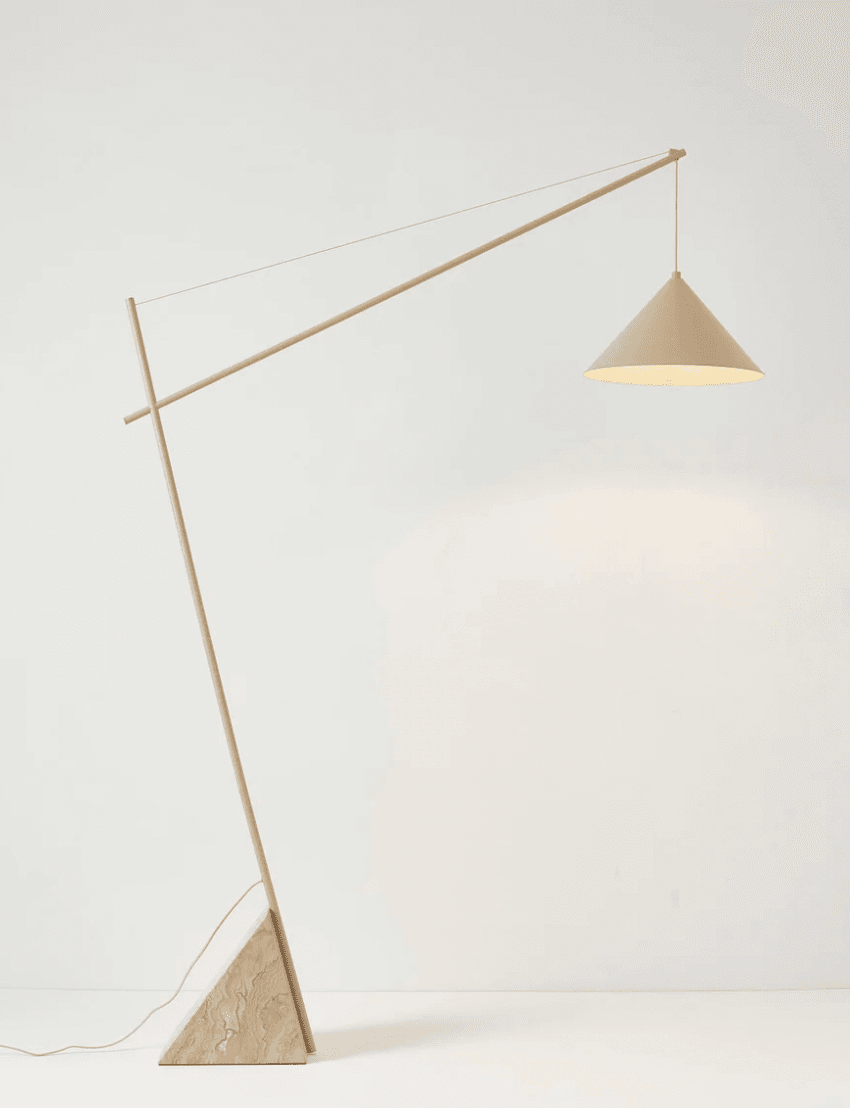 A modern floor lamp with a distinctive, minimalist design. It features a tall, slender stem that extends at an angle, supporting a conical lampshade suspended by a thin wire. The base is a substantial, triangular prism made of veined stone. — 3D model