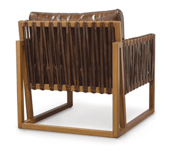 A contemporary lounge armchair featuring a robust, exposed light-toned wooden frame and plush, distressed brown leather upholstery. The design incorporates distinctive woven leather straps on the armrests and front lower rail, secured with metal studs. It has deep seat and back cushions, presenting a blend of rustic and modern aesthetics. — 3D model