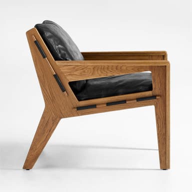 A modern armchair with a solid wood frame and black leather cushions. The frame features a clean, angular design with visible wood grain. Black leather straps are integrated into the sides of the frame, connecting the seat and back support elements. The armchair includes a plush seat cushion and a separate back cushion. — 3D model