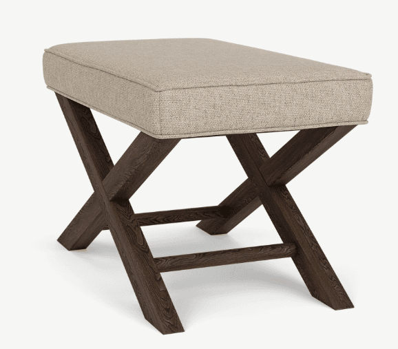 A rectangular ottoman with a cushioned top and a dark wooden base. The base features an X-frame design where two pairs of legs cross each other. The upholstery is a textured, light-colored fabric. — 3D model