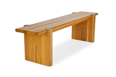 A robust wooden bench constructed from solid oak, featuring a two-plank seat secured by visible circular dowel-like elements on top. The seat rests on two thick, rectangular slab legs, each with a distinctive vertical slot cut into its inner side. The wood has a natural, light brown finish with visible grain, and the edges are gently rounded, contributing to a substantial yet refined aesthetic. — 3D model