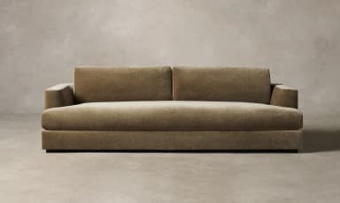 A contemporary sofa with a plush, textured upholstery. It features a low-profile rectangular base, straight arms that curve slightly outwards at the top, and a deep seat cushion. The backrest is divided into two distinct rectangular cushions, providing ample seating space. The overall design is minimalist and modern, with clean lines and a focus on comfort and material. — 3D model