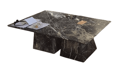 A rectangular black marble coffee table featuring prominent white veining. The tabletop is a solid slab supported by two robust, geometric trapezoidal bases that are also crafted from the same black marble, creating a cohesive and monolithic appearance. The design is modern and minimalist, emphasizing clean lines and natural material. — 3D model