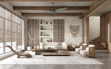 A contemporary two-seat sofa, or loveseat, upholstered in a light beige fabric. It features a minimalist design with track arms, loose back cushions, and a low-profile plinth base, accessorized with throw pillows and a checkered blanket. — 3D model