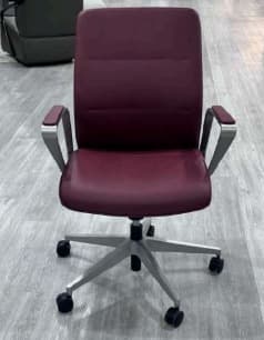 A contemporary office armchair featuring burgundy upholstered seat and backrest, complemented by sleek silver-toned aluminum armrests and a five-star caster base. The chair's design is modern and functional, suitable for a professional setting. — 3D model