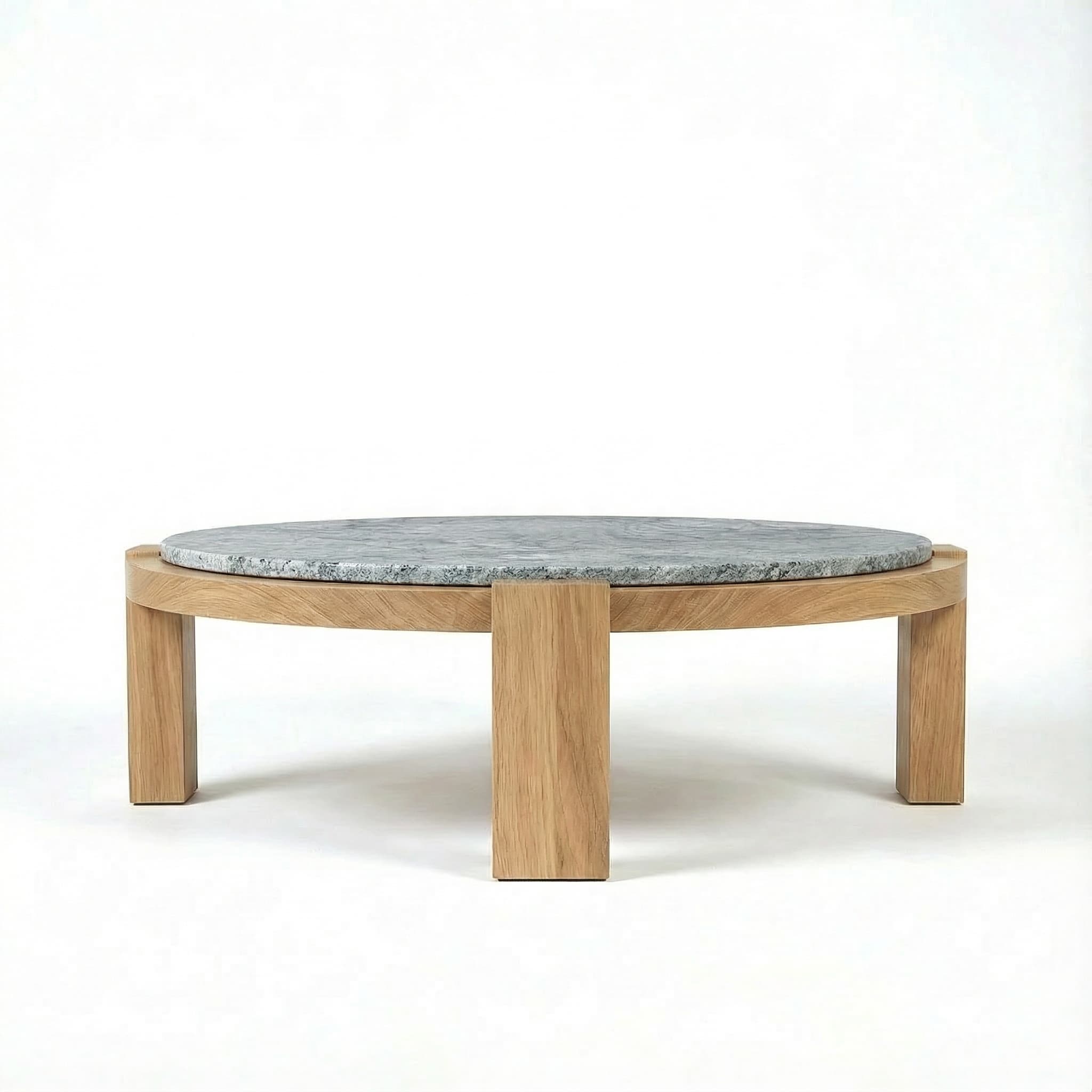 A modern round coffee table featuring a solid oak wood base and a thick, circular grey marble top. The wooden base consists of a circular frame supported by sturdy, rectangular legs. The marble top is recessed into the wooden frame, creating a flush or slightly raised surface. The overall design is minimalist and contemporary. — 3D model