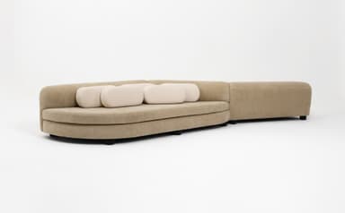 An aerial view of a contemporary two-piece modular sectional sofa featuring an organic, curvilinear shape. The primary upholstery is a textured, light brown or tan fabric. The sofa includes multiple, smaller, rectangular back cushions upholstered in a lighter, cream-colored fabric, arranged in rows on the backrests. The design emphasizes soft lines and a sculptural form. — 3D model