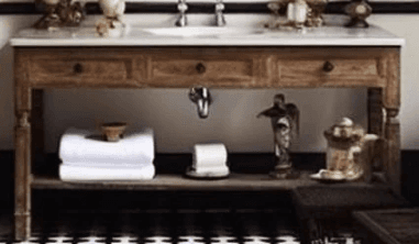 A transitional bathroom vanity featuring a light natural wood frame, a white marble countertop, and an integrated undermount ceramic sink with a polished chrome faucet. The unit includes two functional drawers with simple round pulls and a spacious open lower shelf for storage and display, supported by four tapered legs. — 3D model