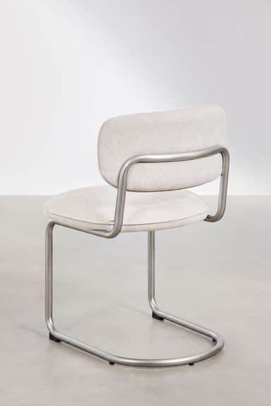 A modern armless chair featuring a bent tubular steel frame in a matte silver finish, with a padded, upholstered seat and a small, separate backrest covered in light-colored fabric. — 3D model