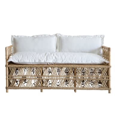 A rattan daybed with a woven geometric pattern on the sides and back. It features thin, cylindrical legs and is topped with two white pillows and a white mattress or cushion. — 3D model