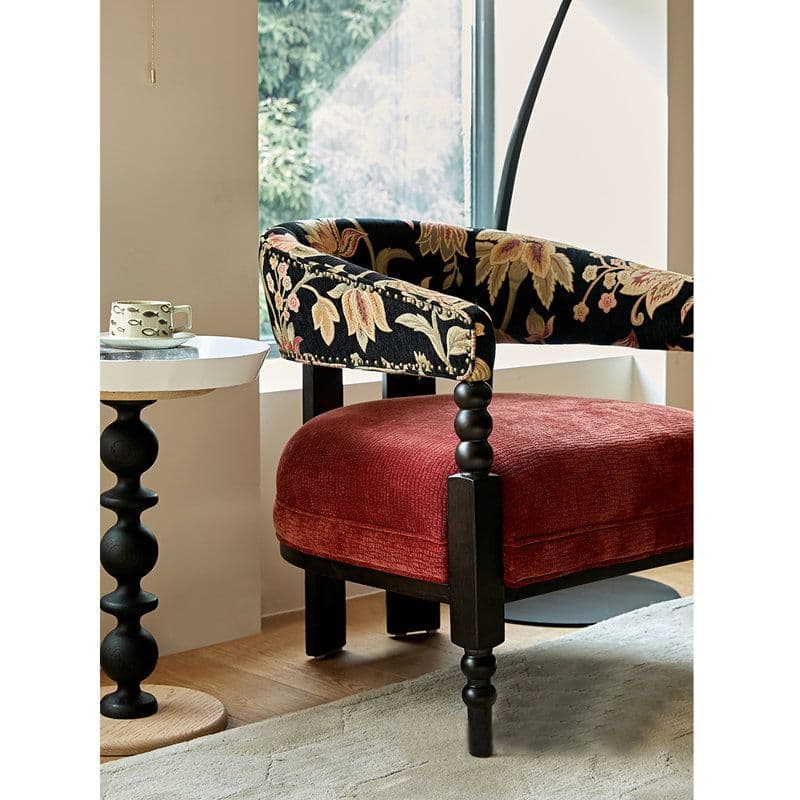 An upholstered barrel armchair featuring a continuous rounded back and armrests with floral pattern upholstery, a contrasting red velvet seat cushion, and dark turned wooden legs. — 3D model