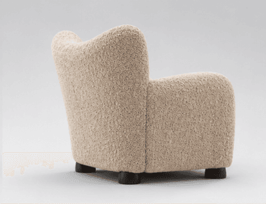 A modern upholstered armchair featuring a distinctive highly textured, beige fabric and a rounded, inviting silhouette, set on small, dark wooden feet. — 3D model