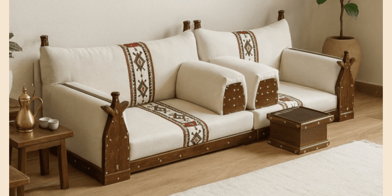 A low-profile, modular sofa with a wooden frame and upholstered cushions. The cushions are cream-colored with decorative tribal-inspired bands of red, white, and black geometric patterns. The wooden frame is dark brown and features carved elements and decorative metal tacks. The sofa is comprised of multiple sections, including a main seating area with back cushions and armrests, and a smaller modular unit that appears to function as an end table or ottoman. — 3D model