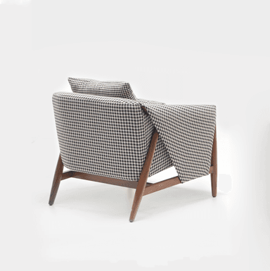 An upholstered lounge chair featuring a distinctive black and white houndstooth fabric pattern and an exposed dark wooden frame. — 3D model