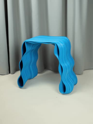 A contemporary stool with a fluid, wave-like design. The structure is composed of numerous thin, layered strips of material that form the seat and the curved, undulating legs. The bright blue color with varying shades and fine white lines creates a dynamic, visually interesting pattern, mimicking the appearance of wood grain or layered composite material. It is presented against a neutral background with soft drapery. — 3D model