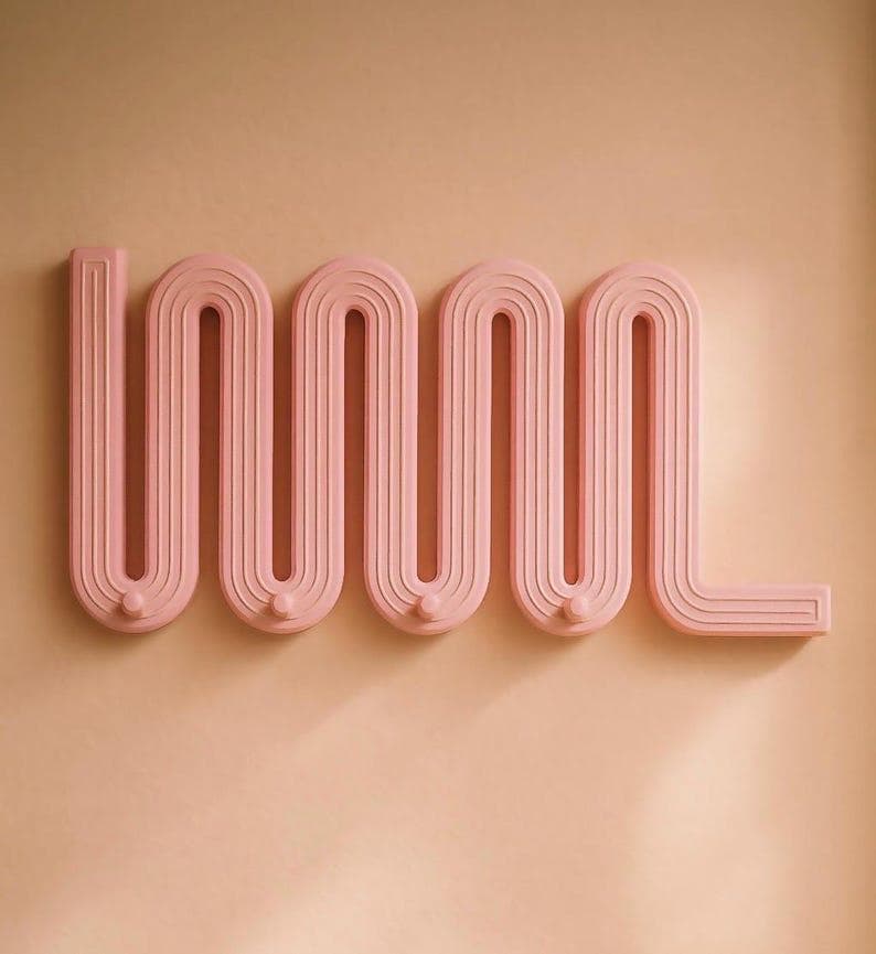 A contemporary wall-mounted coat rack featuring a distinctive wavy, zigzag design with integrated hooks, presented in a matte pink finish. — 3D model