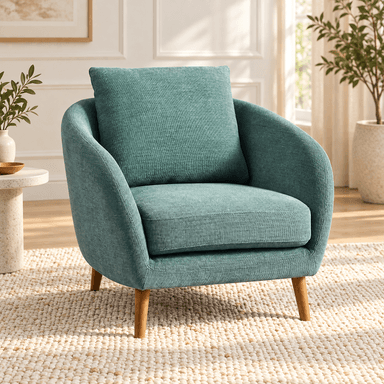 A modern upholstered armchair featuring a curved barrel-style back and integrated arms. The chair is covered in a textured mint green or teal fabric and rests on four light-colored wooden legs that splay slightly outwards. It includes a firm, removable seat cushion and a loose back pillow for comfort. — 3D model