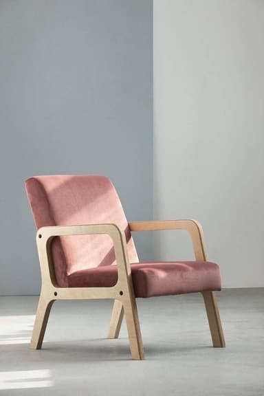 A single armchair featuring a light-toned, exposed wooden frame with a pink fabric upholstered seat, backrest, and padded armrests. The design is contemporary with clean lines and visible hardware. — 3D model