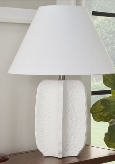 A white table lamp with a conical lampshade and a textured, sculptural base. The base has a rough, organic surface with vertical indentations or folds, giving it a unique tactile quality. The lampshade is smooth and appears to be made of fabric. — 3D model