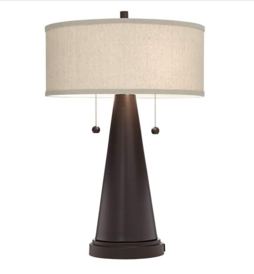 A contemporary table lamp featuring a dark, conical metal base that tapers upwards from a round foot. It is topped with a cylindrical drum shade made of light-colored fabric. The lamp is equipped with two pull chain switches, indicating multiple light sources or settings. — 3D model