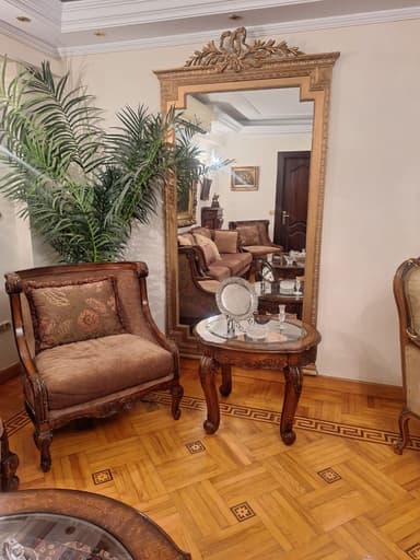 A tall, rectangular wall mirror featuring an elaborately carved and gilded frame, topped with a prominent Rococo-style crest of acanthus leaves and a central ribbon or bow motif. — 3D model