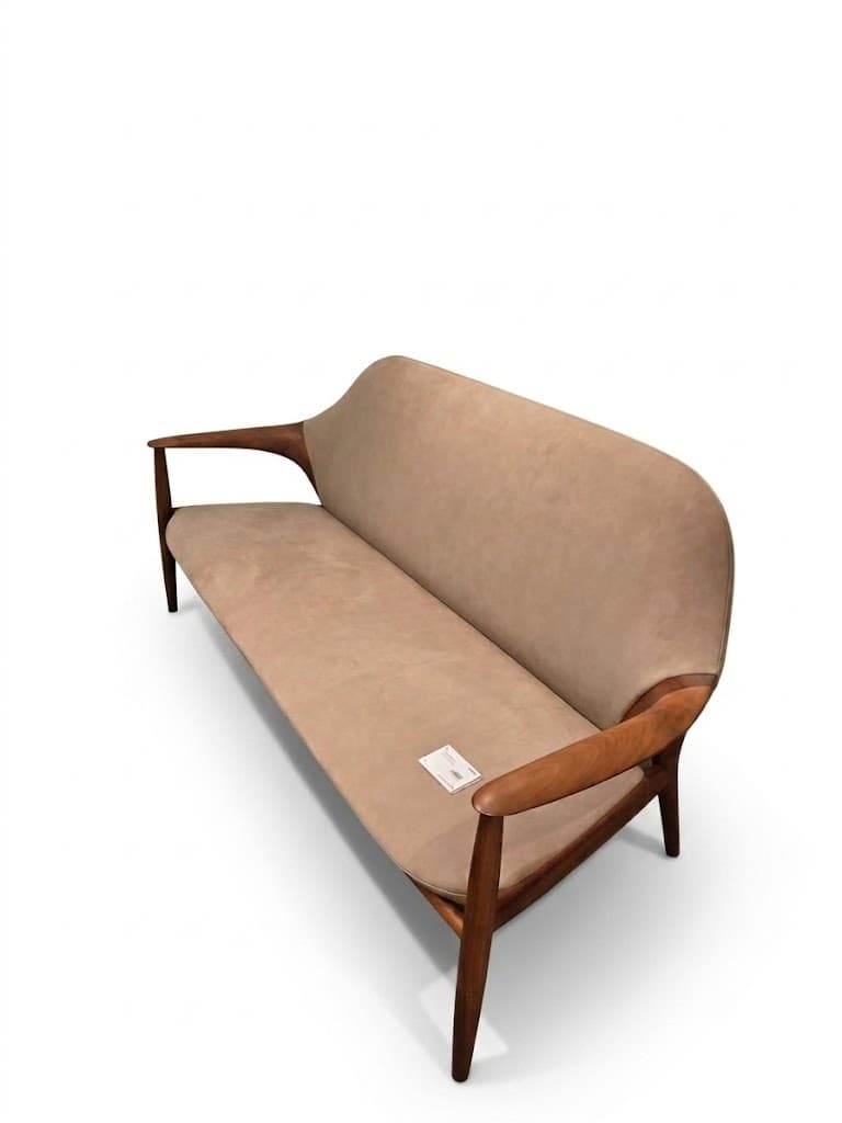 A two-seater sofa or loveseat featuring a visible wooden frame and light beige upholstery. The frame has a distinct, curved design, forming both the armrests and the legs. The backrest is gently curved, offering a streamlined aesthetic. — 3D model