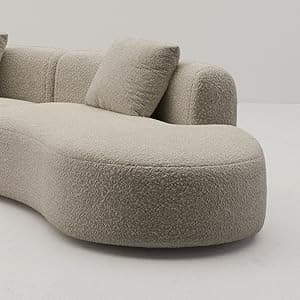 A large, modular, curved sofa with a textured, boucle-like upholstery. The sofa features rounded edges and appears to be composed of at least two connected sections, forming a sweeping arc. It includes two square throw pillows that match the sofa's upholstery. The design is contemporary with a soft, inviting aesthetic. — 3D model