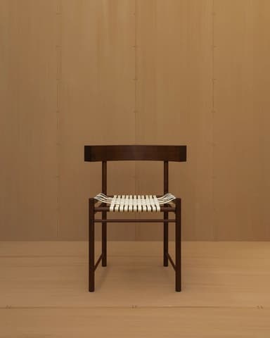 An armless modern side chair featuring a dark-stained solid wood frame and a seat woven with white straps. The backrest is a gently curved, solid piece of wood. The chair exhibits clean lines and a minimalist aesthetic. — 3D model
