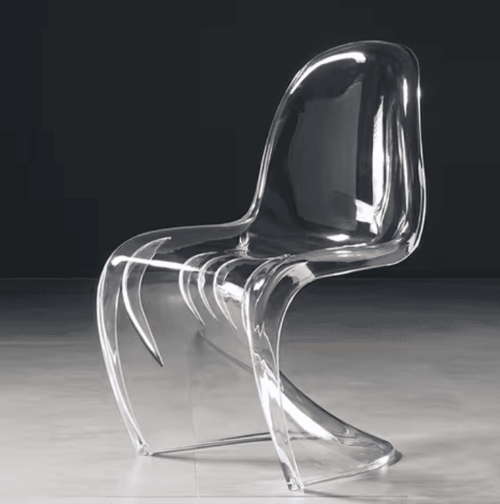 A modern, transparent acrylic chair with a distinctive S-shaped silhouette. The chair features a continuous, fluid form that serves as the seat, backrest, and legs. The backrest has a series of vertical, fin-like supports that add structural detail and visual interest. The material appears to be a single molded piece of clear acrylic or polycarbonate. — 3D model
