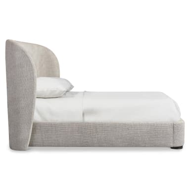 A modern platform bed featuring a fully upholstered frame and headboard in a light beige, textured fabric. The headboard has gently rounded top corners, presenting a soft, contemporary silhouette. The low-profile design is supported by small, dark, cylindrical feet, creating a clean and minimalist aesthetic. — 3D model